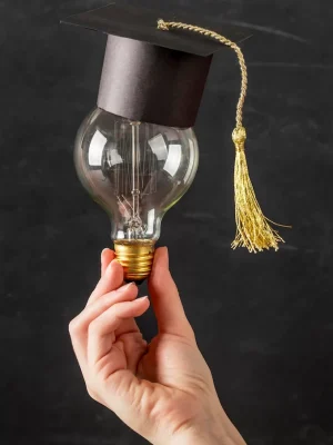 person-holding-light-bulb-with-graduation-cap_23-2148721299